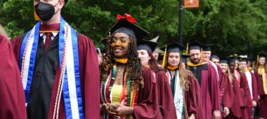 This is a photo of the Class of 2022 walking and smiling before commencement.